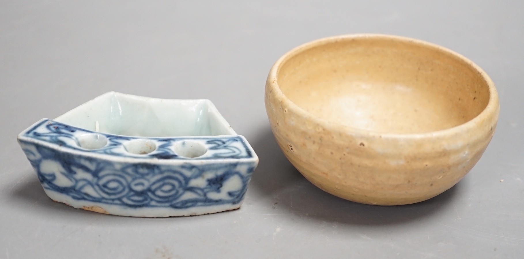 A Chinese late Qing blue and white penholder, 8cm and a South East Asian buff glazed cup